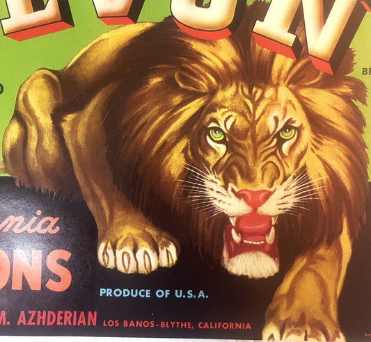 Vintage fruit crate label featuring a roaring lion's head with yellow eyes and red mouth against green and black background,