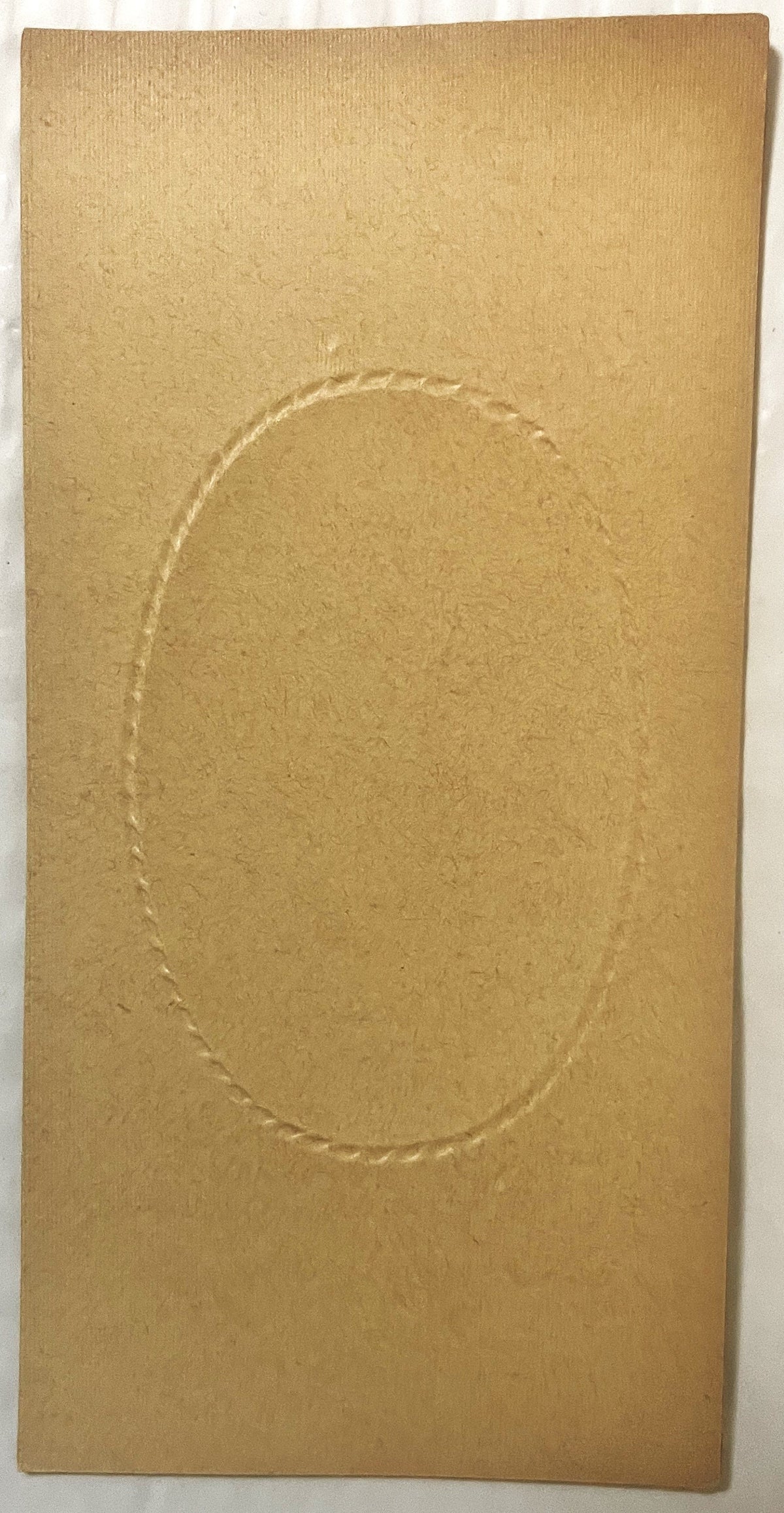 Tan cardboard box insert with embossed oval frame, photographed flat against white background