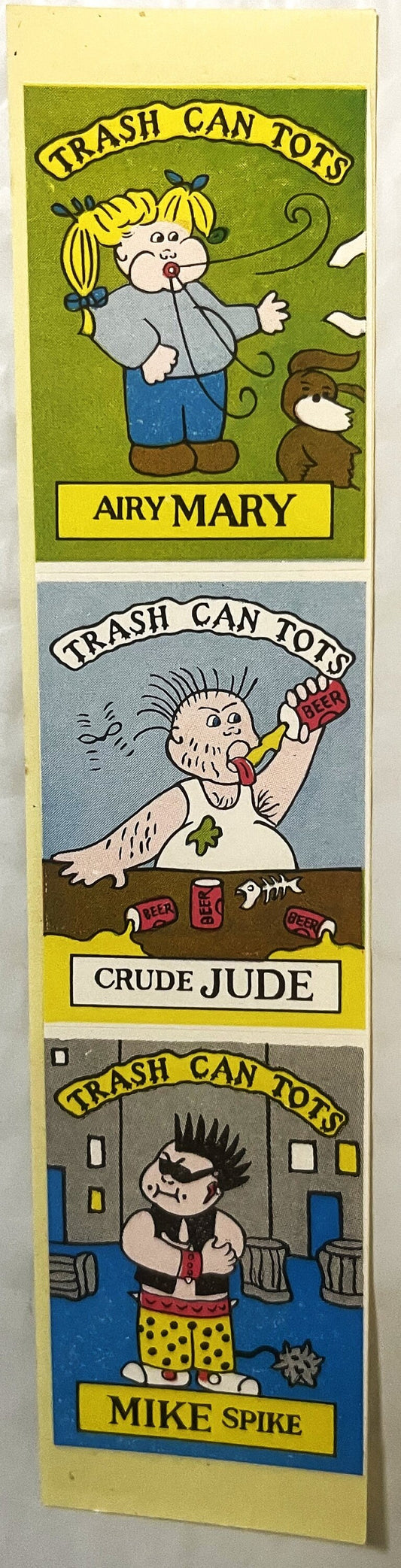 Three vintage Trash Can Tots stickers featuring Airy Mary, Crude Jude, and Mike Spike characters on yellow backing card