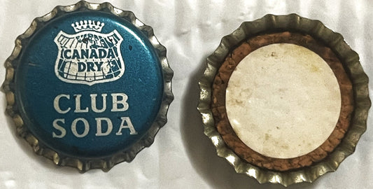 Two views of a Canada Dry Club Soda bottle cap: front showing blue crown logo and text, back showing cork lining in cream and