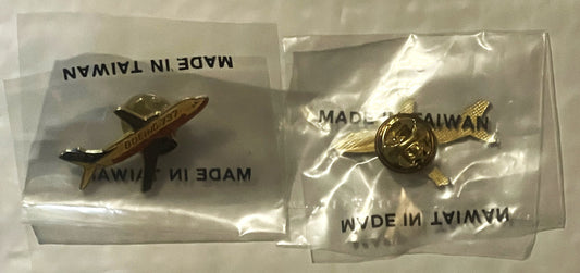 Two sealed plastic packets containing gold-toned airplane lapel pins marked "Made in Taiwan," photographed from above
