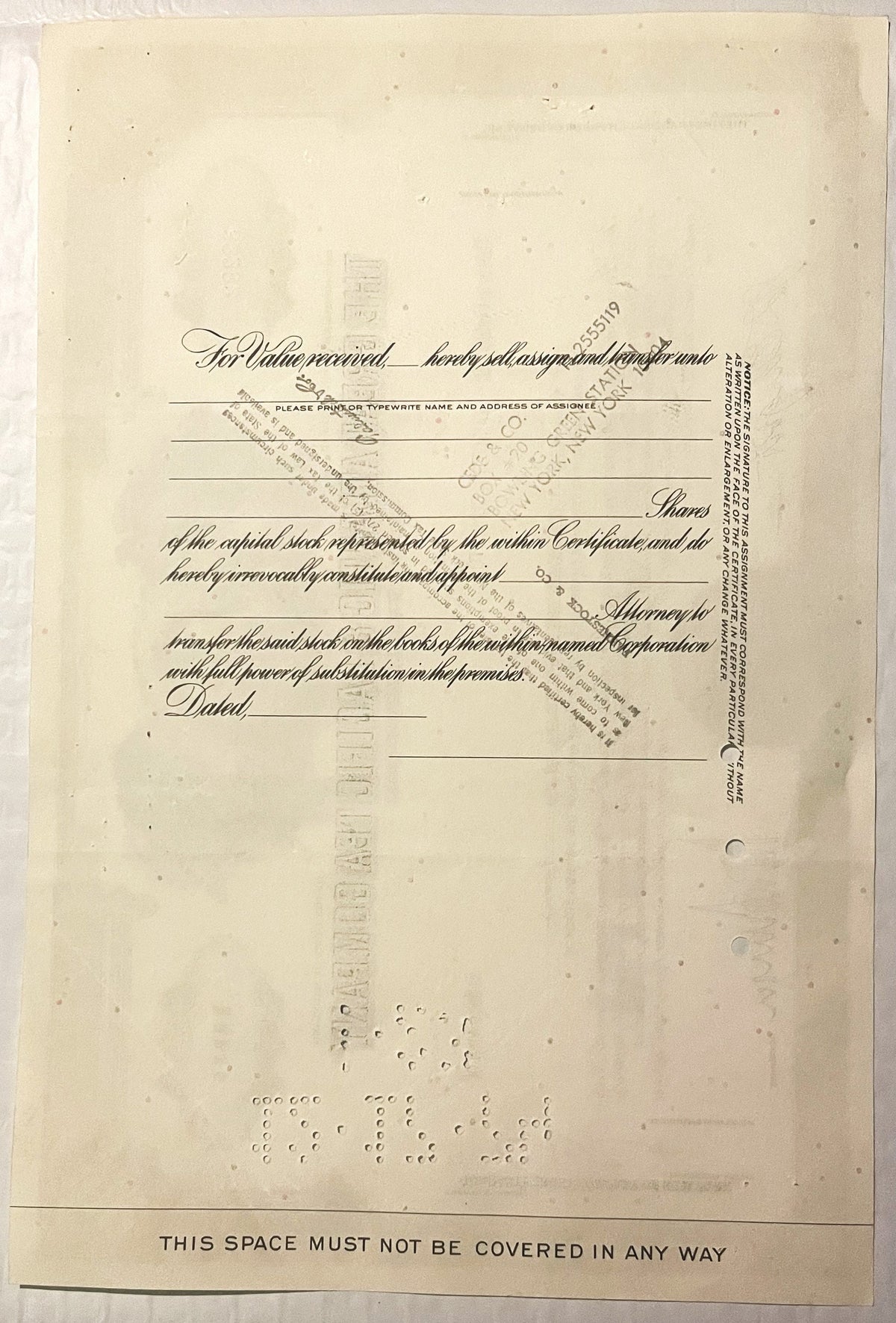 Yellowed vintage stock certificate form with ornate cursive text, blank lines for assignee information, and "THIS SPACE MUST