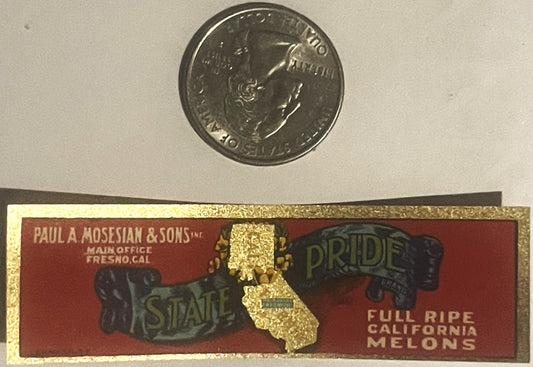 Vintage California State Pride melon label next to a quarter for scale, showing red background with gold state outline and te