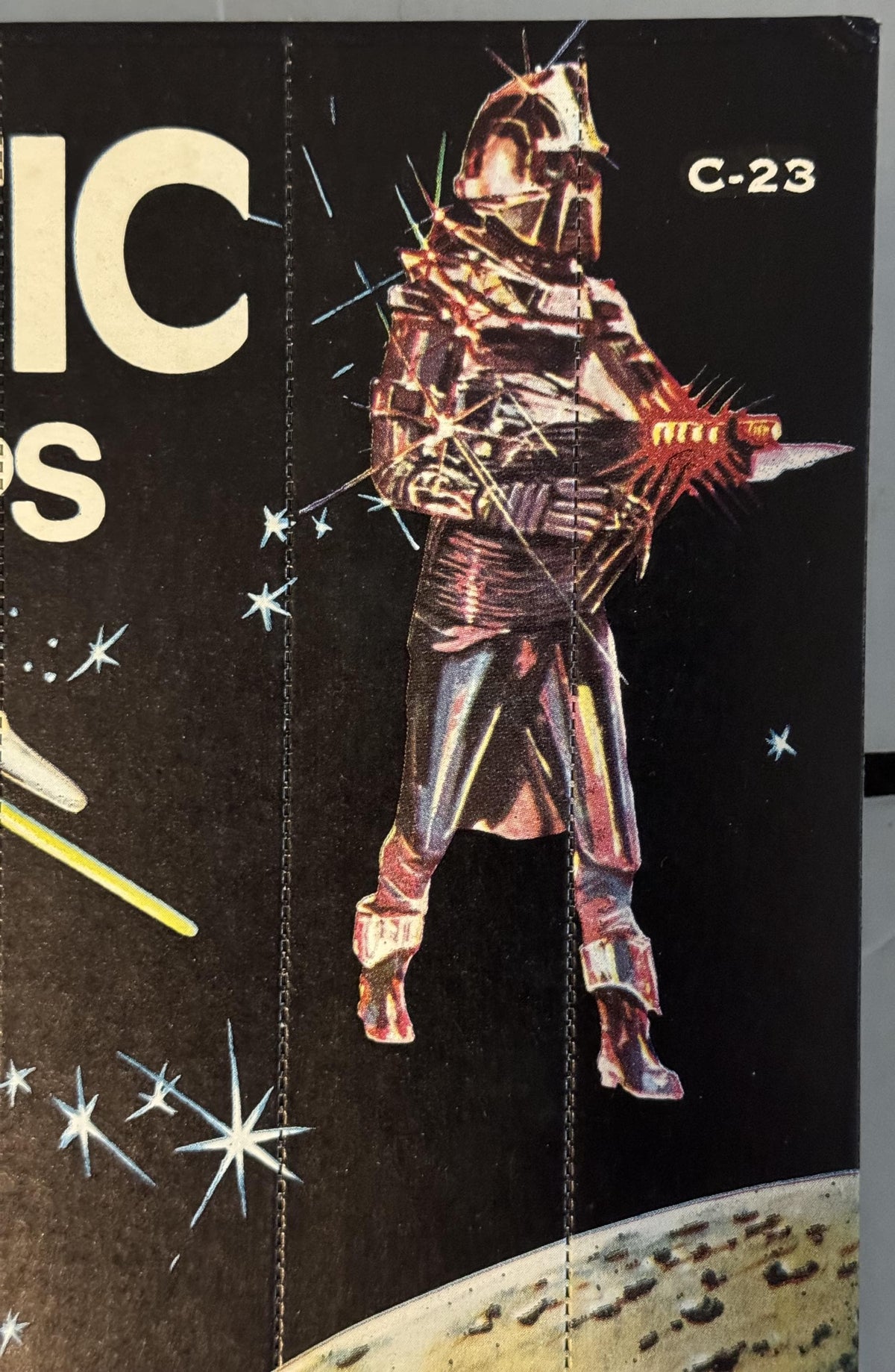 Vintage sci-fi vending card showing armored alien warrior figure in red and gold suit with spikes against black