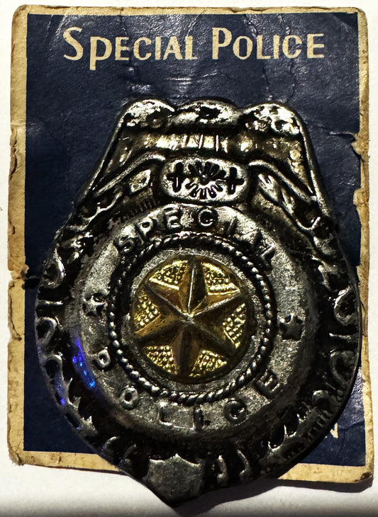 Vintage metal badge on original card reading "SPECIAL POLICE" with eagle emblem and gold star center, shown at angle against