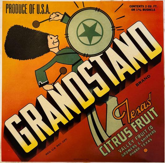 Vintage citrus crate label featuring a cartoon soldier holding a large drum labeled "GRANDSTAND" against an orange and red ba