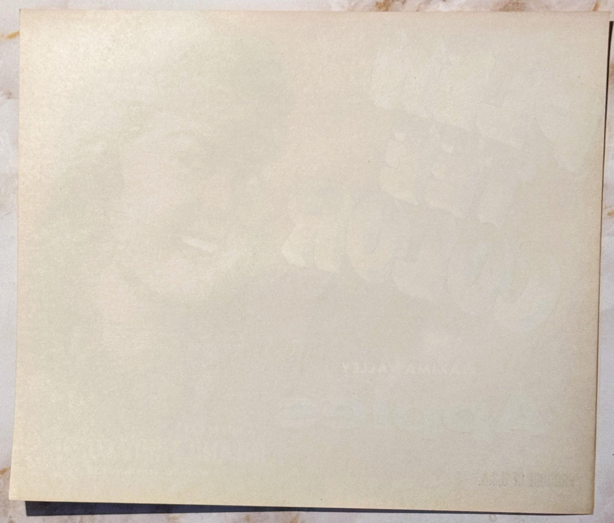 Blank cream-colored vintage fruit crate label with dark border, photographed flat against light background