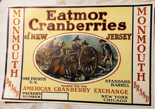 Vintage Monmouth Brand cranberry barrel label featuring colonial figures with cart, orange and red text on cream background