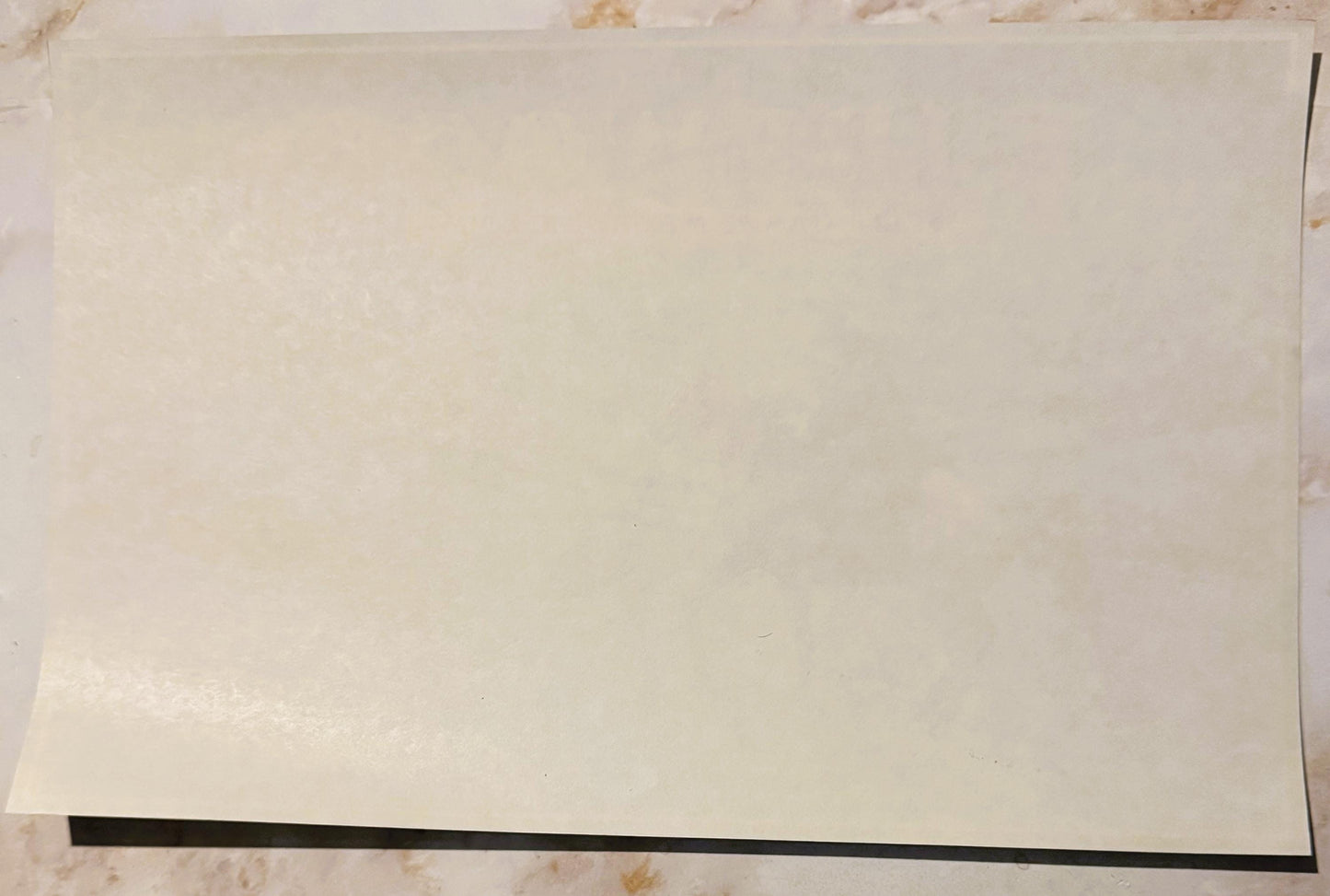 Cream-colored vintage crate label with black border stripe along bottom edge, displayed flat on textured surface