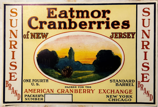 Vintage cranberry barrel label featuring "Eatmor" branding, pastoral sunset landscape illustration, red and orange text on cr