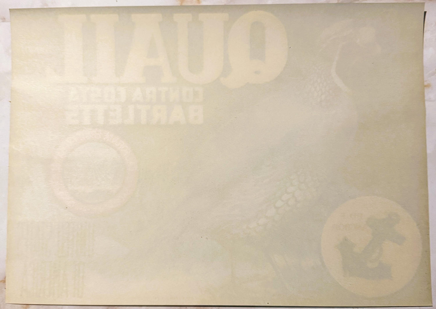 Faded cream-colored vintage crate label with embossed "QUAIL" branding and partially visible text, photographed flat against