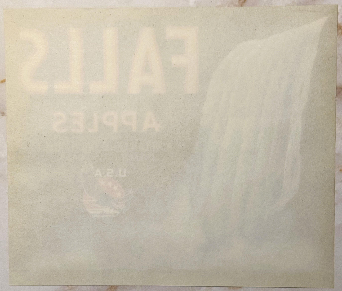 Faded vintage apple crate label with embossed text on cream-colored paper, showing watermarked design and partial lettering