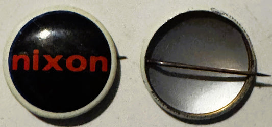 Front and back views of a round campaign button with cream-colored rim, black dome, and red "nixon" text, with metal pin clos