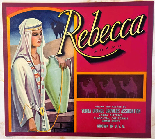 Vintage Rebecca Brand fruit crate label featuring woman in white Middle Eastern dress holding green bottle, with camels silho