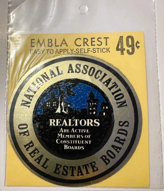 Vintage 49-cent self-stick emblem crest in plastic package showing National Association of Real Estate Boards seal with citys