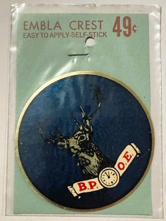 Vintage self-stick emblem crest showing elk head on dark blue oval with B.P.O.E. banner, gold border, priced 49 cents on gree