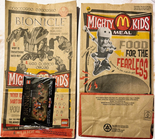 Front and back of tan paper McDonald's Mighty Kids Meal bags from 2002 with Bionicle LEGO promotion and unopened black Bohrok
