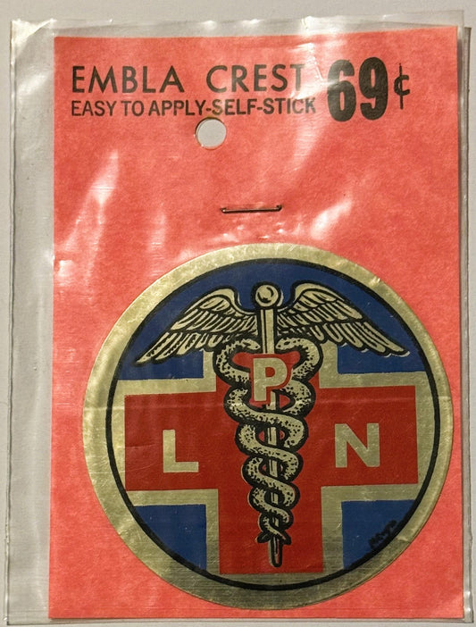 Vintage self-stick emblem crest decal priced 69¢, featuring medical caduceus symbol with wings on red cross and blue backgrou