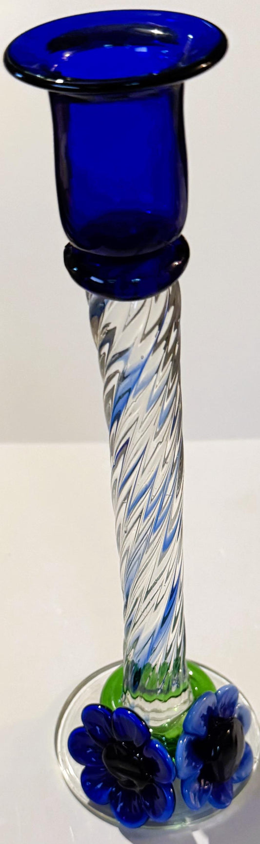 Tall blue art glass candlestick with twisted clear and white latticino stem, blue bowl top, and applied blue flower decoratio