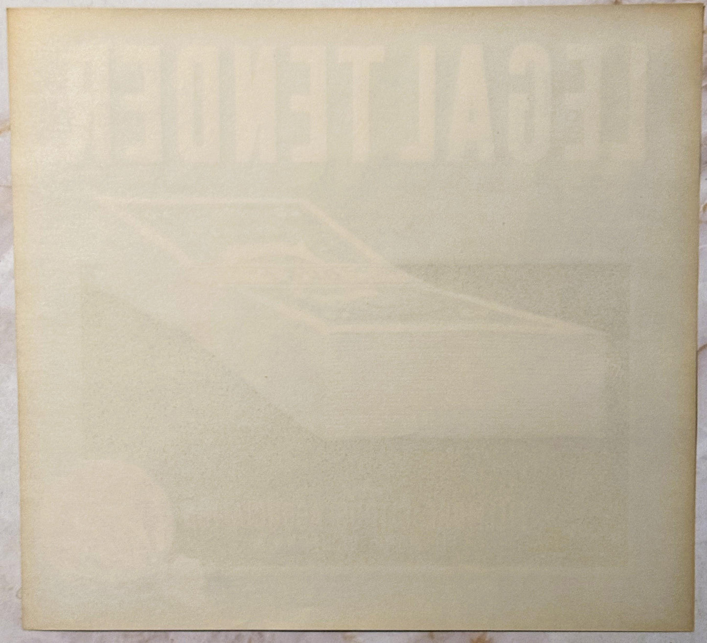 Cream-colored vintage crate label with faint embossed or printed text, shown flat against white surface