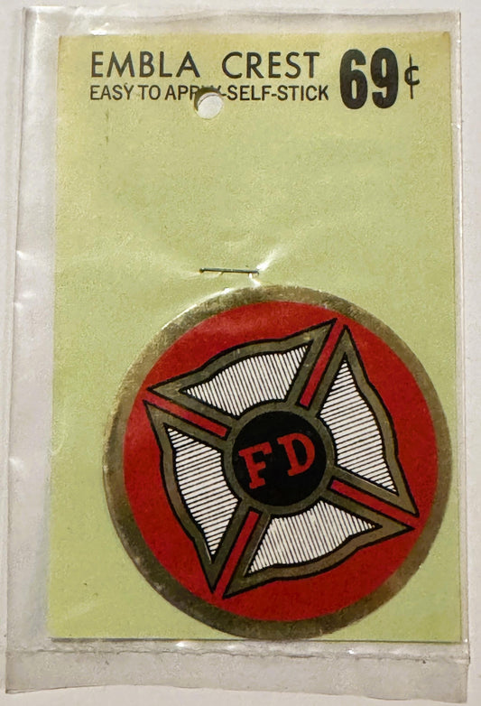 Vintage FD fire department self-stick emblem crest with red circular background, Maltese cross design, and tan border on yell