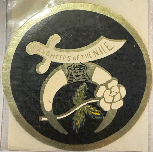 Circular vintage decal with cream border featuring a stylized female figure in ornate dress holding a white flower, with "DAU