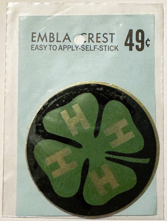 Vintage Embla Crest self-stick decal with green four-leaf clover design and tan lettering on light blue packaging, priced at