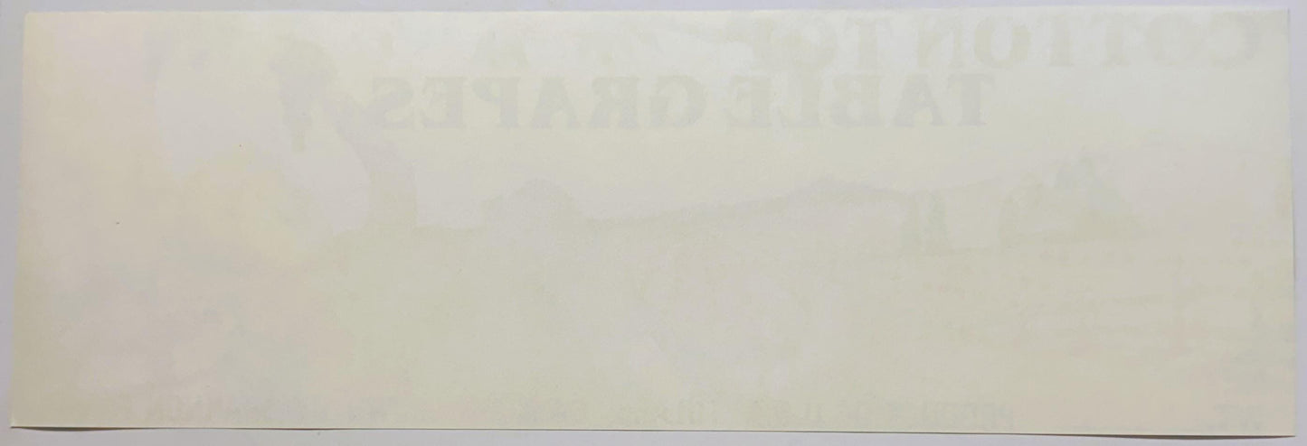 Faded vintage crate label with cream background and barely legible text, photographed flat against white surface