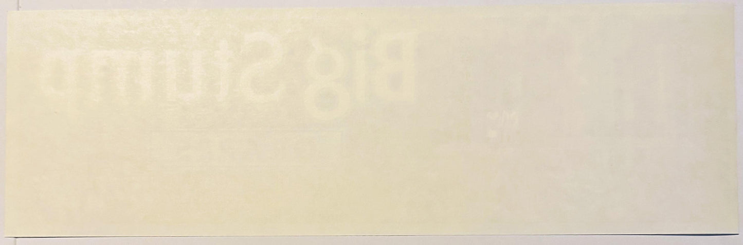 Cream-colored vintage fruit crate label with faint printed design, photographed flat against neutral background