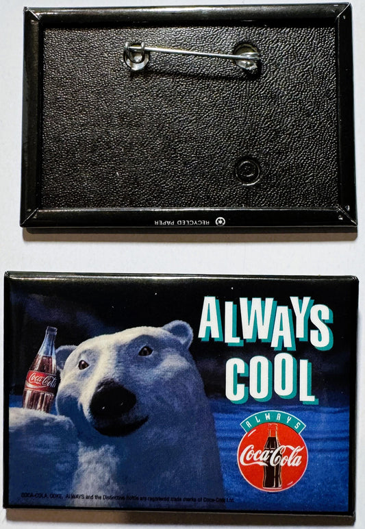 Vintage Coca-Cola pin showing front and back: textured black enamel back with safety pin, colorful front featuring polar bear