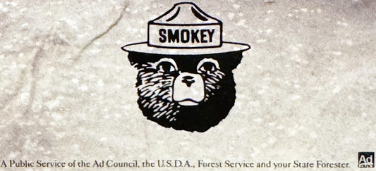Black and white illustration of Smokey the Bear wearing a ranger hat with "SMOKEY" text, on textured light background with at