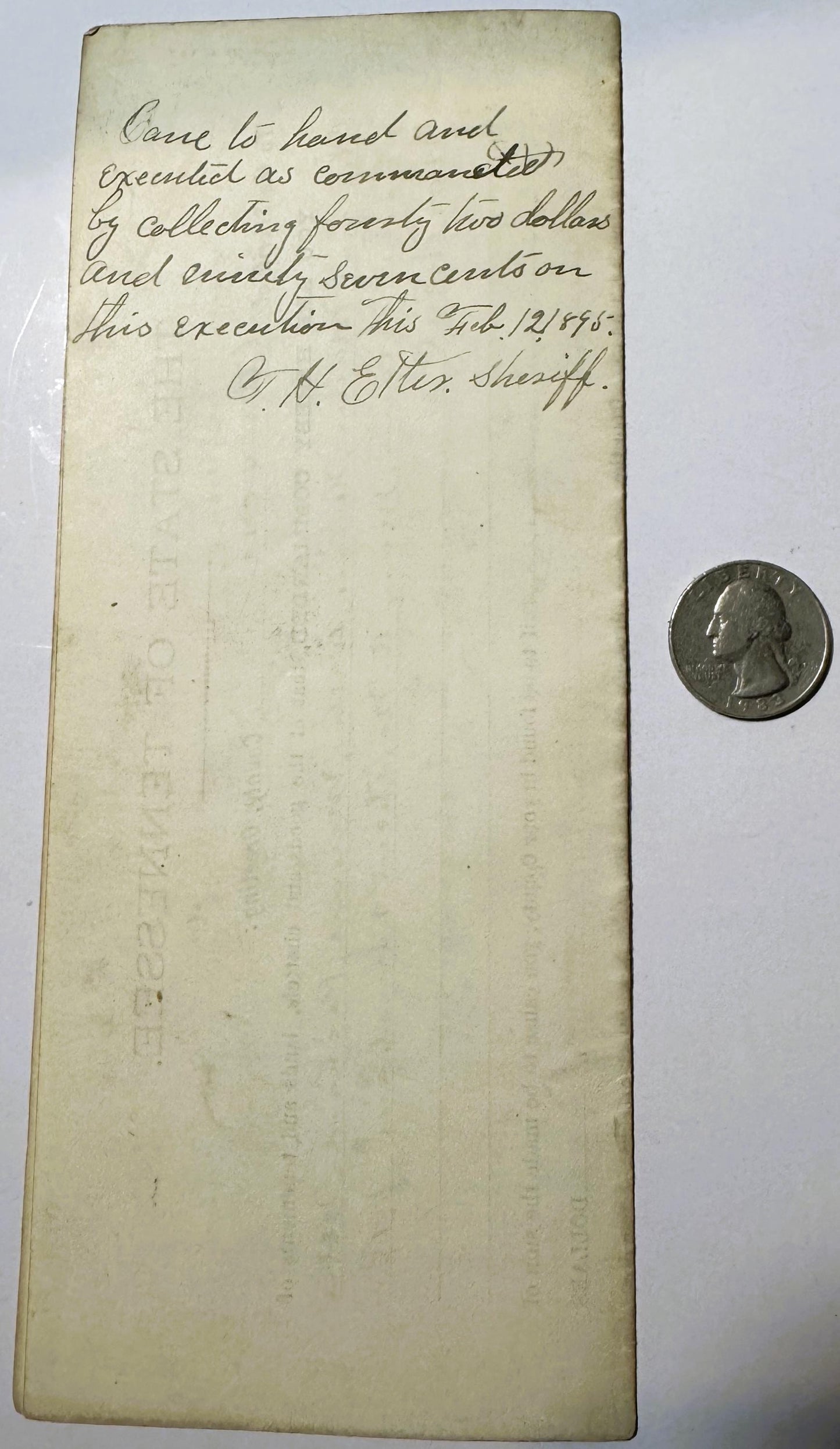 Handwritten 1893 Tennessee legal document with quarter coin for scale, yellowed paper showing cursive text