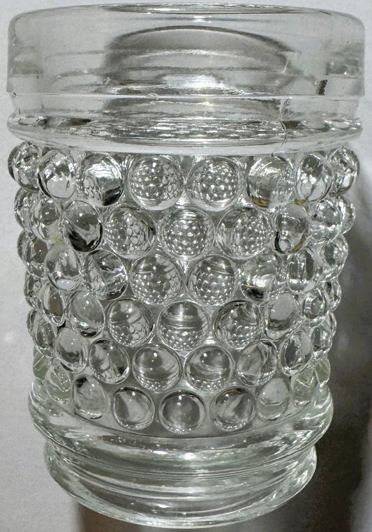 Clear glass hobnail tumbler with bubble texture, shown straight-on against white background, glass lid visible at top.