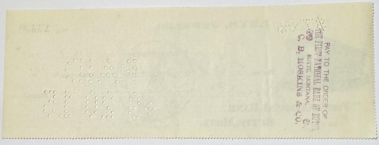 Back of vintage bank check from Butte, Montana jeweler with embossed circles forming numbers, postage stamp visible in upper