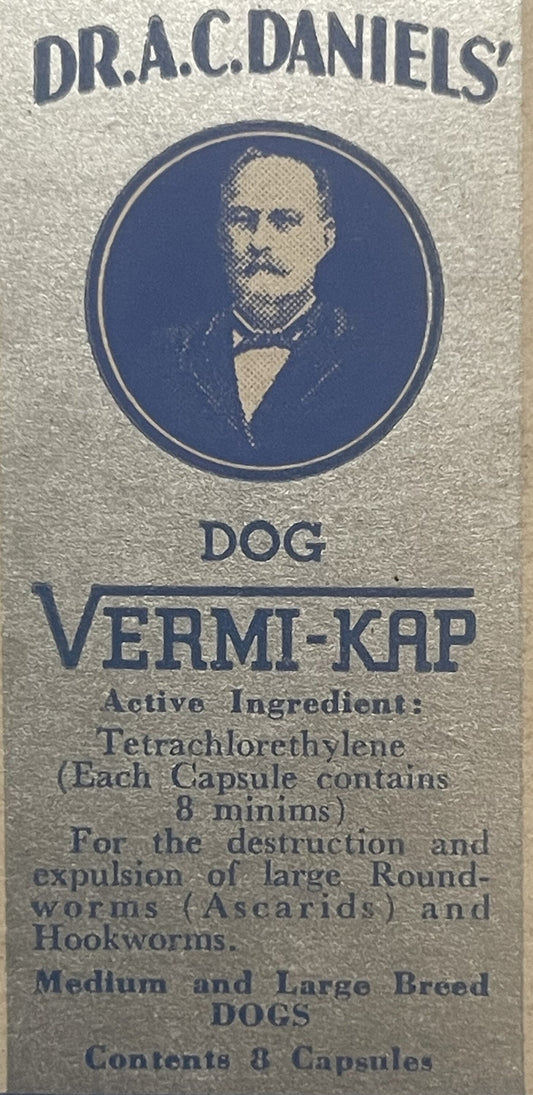 Vintage dog medicine box label showing Dr. A.C. Daniels' portrait and text for Vermi-Kap parasite treatment capsules in blue
