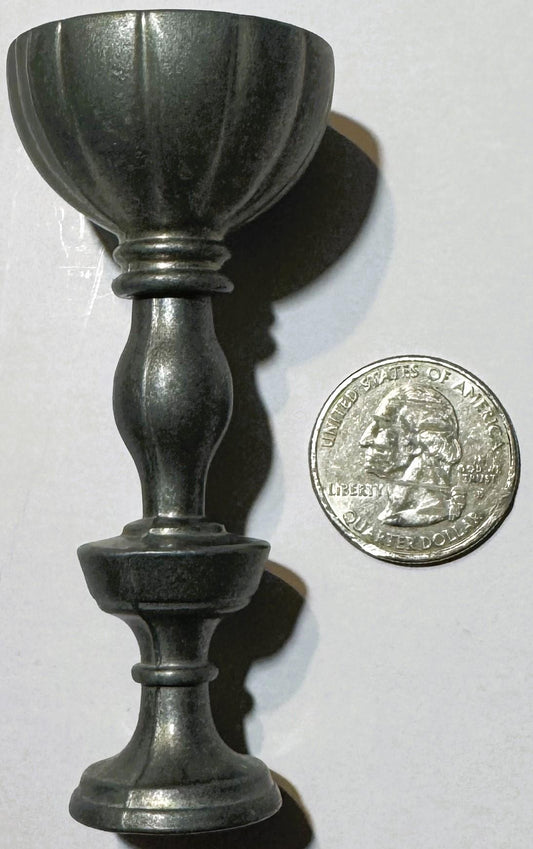 Miniature pewter goblet with fluted bowl and baluster stem next to US quarter for scale, showing patina and maker's stamp