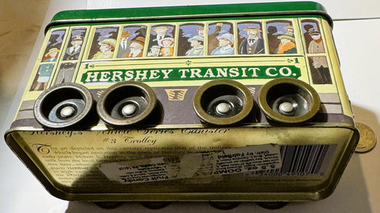 Vintage Hershey Transit Co. brass tin box with green lid, four metal wheels, and illustrated passengers in windows.