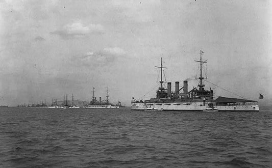 Black and white photograph of US Navy battleships at anchor, with multiple vessels visible and two prominent warships in fore