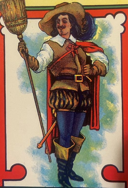 Colorful lithographed broom label featuring a bearded cavalier in red cape and feathered hat holding a broom, with red border