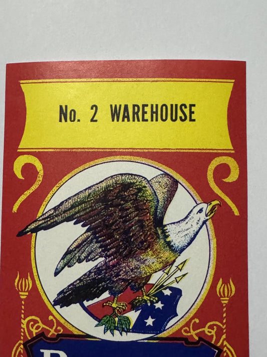 Top of the label: No. 2 WAREHOUSE in black on the yellow banner, above the eagle roundel and the yellow scrollwork