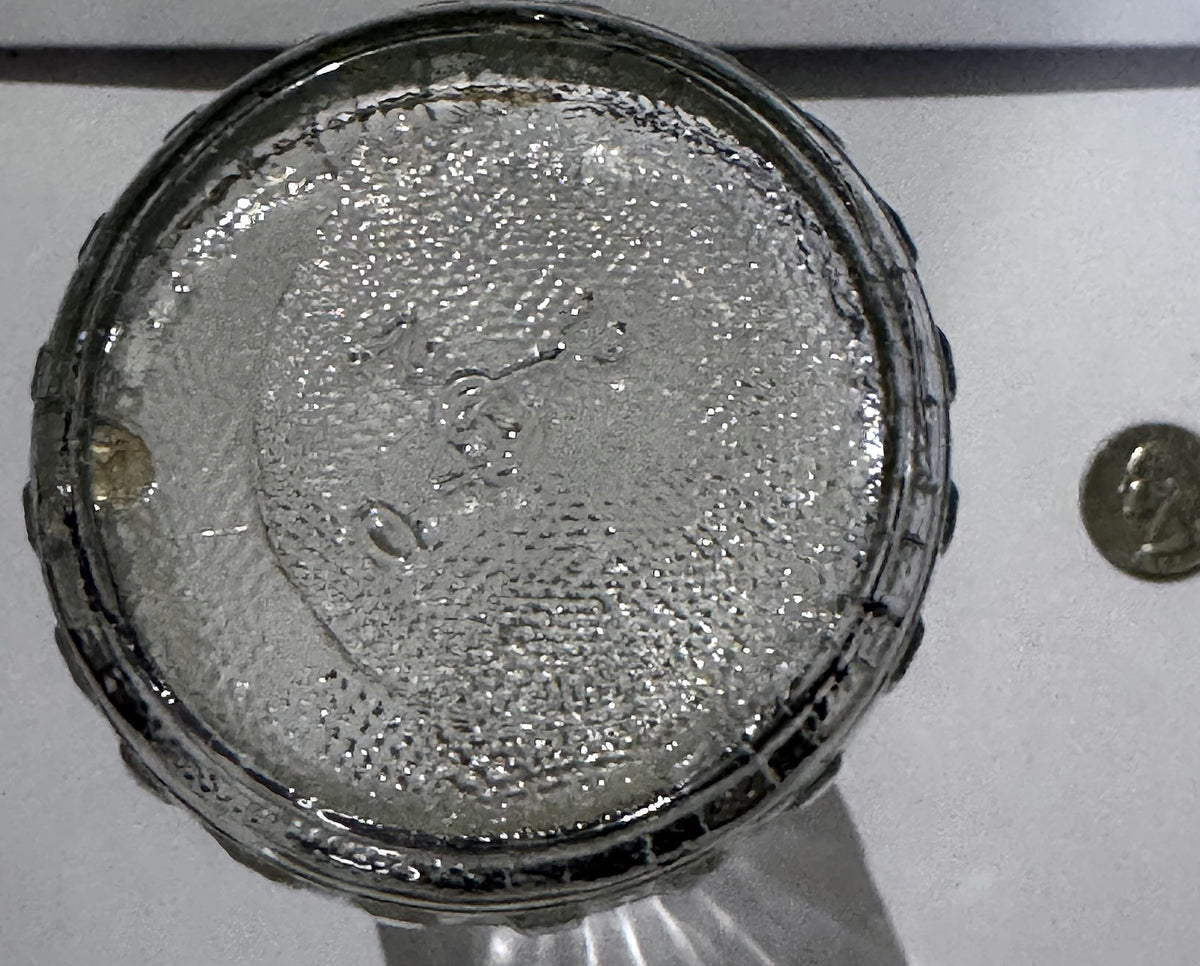 Stippled glass base of the Nyseptol bottle with its embossed mark