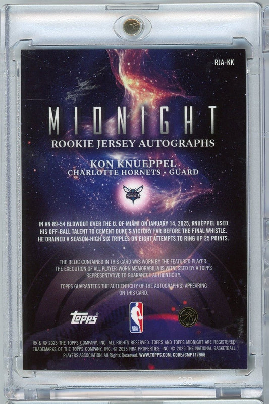 Back of slabbed rookie card displaying purple galaxy background with white text describing Kon Knueppel's performance and card authenticity details.
