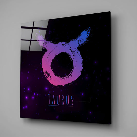 Angled perspective of glass wall art displaying a pink and blue brushstroke Taurus symbol against a dark starry background with "TAURUS" text.