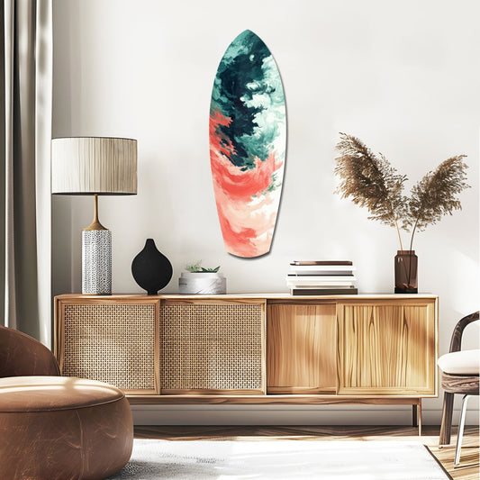 Surfboard-shaped glass wall art with teal and coral abstract paint patterns displayed above a wooden credenza in a modern living room setting.