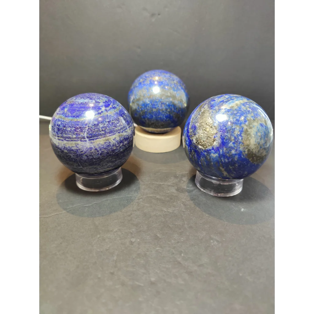 Three lapis lazuli polished spheres displaying deep blue color with golden pyrite and white veining polished sphere sculpture