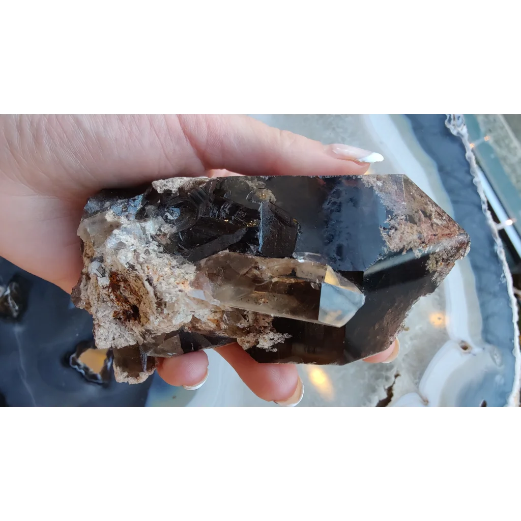 Hand holding lodalite included smoky quartz with phantom crystals from Brazil
