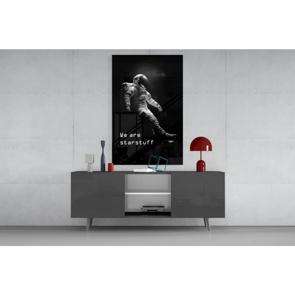 Black-and-white astronaut wall art poster on gray table, we are starstuff print
