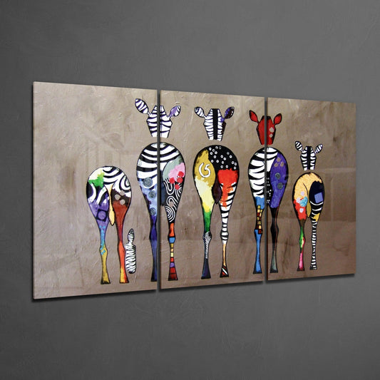 Three-panel glass wall art displaying stylized zebras with striped legs and colorful patterned bodies against a beige textured background.