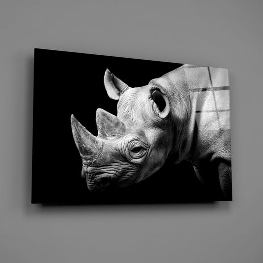 Black and white detailed rhino head portrait on glass wall art against gray wall, showing side profile with textured skin detail.