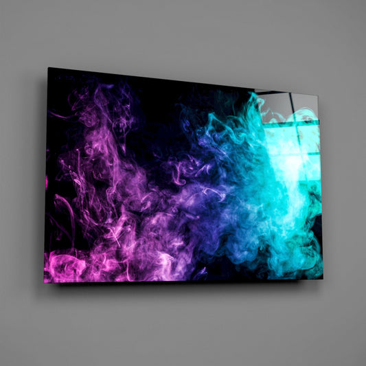 Angled front view of glass wall art displaying swirling magenta and cyan smoke clouds against black background, mounted on gray wall.